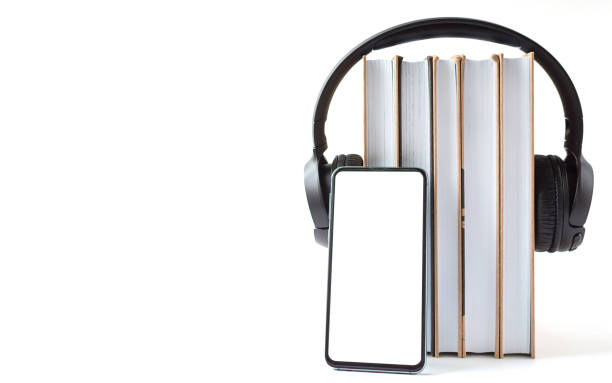 headphones, phone and books on a white background. Audiobook concept headphones, phone and books on a white background. Audiobook concept. audio book stock pictures, royalty-free photos & images