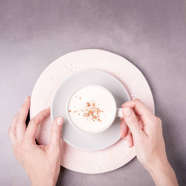 istock Female hands holding gray coffee cappuccino cup with Ceylon cinnamon 1289254053