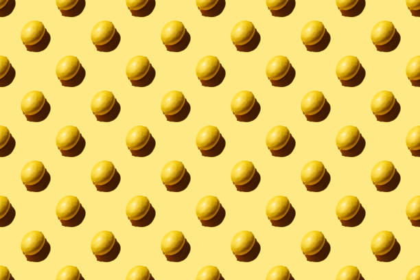 istock Trendy pattern made with fresh fruits on bright light yellow background. Minimal style with colorful paper backdrop. Colorful photo. Flat lay. Minimal creative concept. Food background. Lemons 1289255273