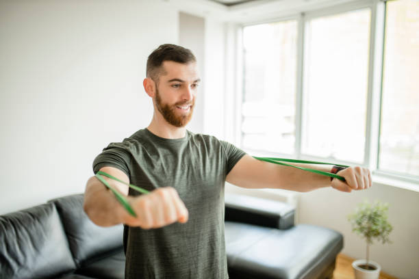 istock Sporty man  doing exercises with resistance band at home 1289256390