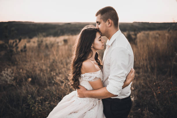 istock bride and groom walking on the meadow in summer at sunset 1289256997