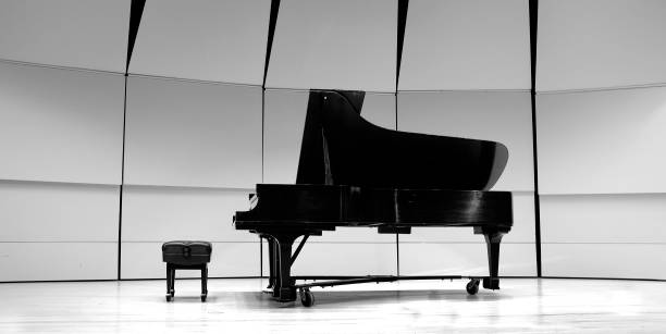 Black and white piano with bench on concert state for performance Black and white piano with bench on concert state for performance conservatory education building stock pictures, royalty-free photos & images