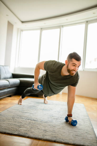 istock Man doing push ups with dumbbells at home 1289258058