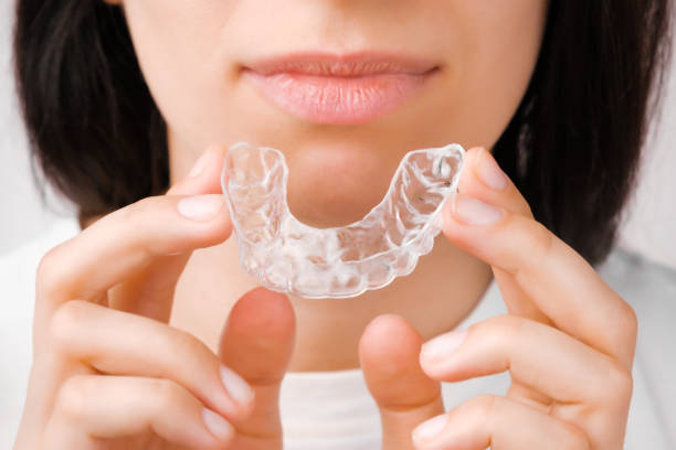 istock Smiling woman with perfect and healthy teeth using removable braces or aligner for straightening and whitening teeth. Orthodontic treatment for correction of bite. 1289258124