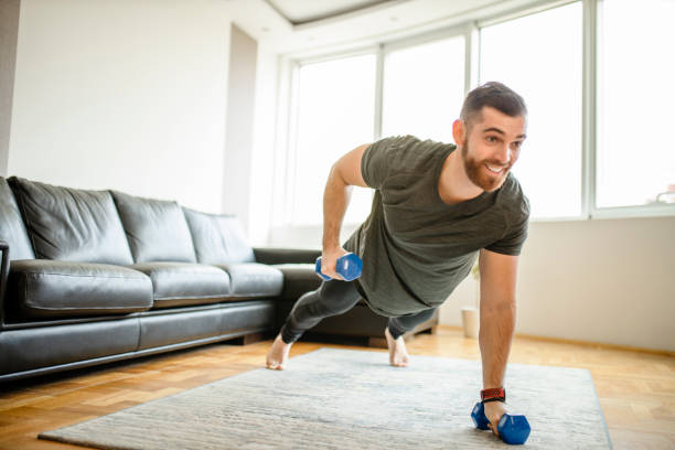 istock Man doing push ups with dumbbells at home 1289258206