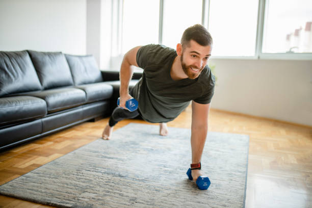 istock Man doing push ups with dumbbells at home 1289258305