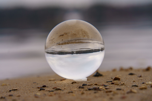 Photography of clear crystal ball. River  as background. Miracle view. Concepts of beauty of the nature.  Natural backgrounds.