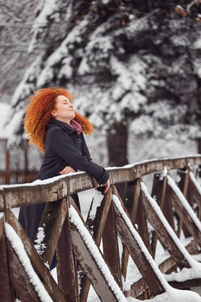 istock Beautiful young woman having fun outdoors in winter forest 1289260532