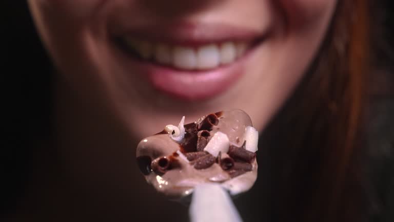 Young woman mouth eating chocolate ice cream