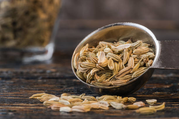 sementes de erva-doce derramadas de uma colher de chá - fennel spice spilling seed - fotografias e filmes do acervo