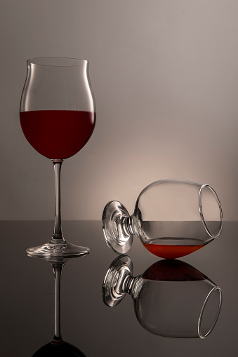Red wine glass with wine in the center of pictures. The wine moves slightly up the glass.