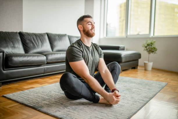 istock Young man exercising and stretching at his home 1289262630