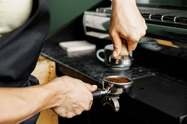istock Woman coffee shop worker preparing coffee on professional coffee machine 1289263802