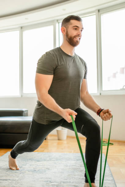 istock Sporty man  doing exercises with resistance band at home 1289265106