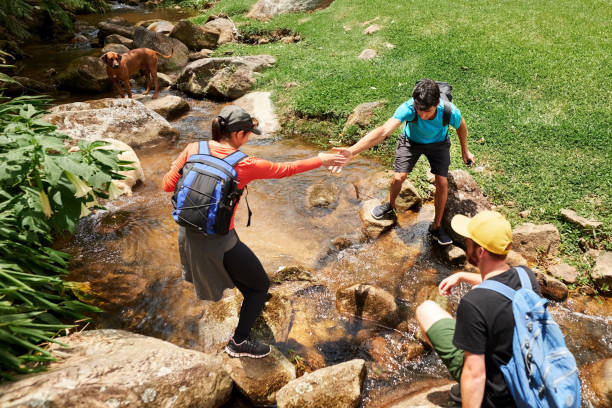 istock Hiker helping a friend crossing mountain creek 1289267244