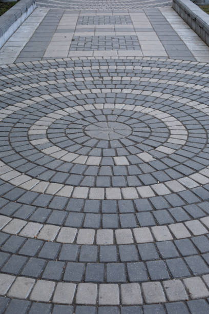 istock The path is paved with two shades of gray stone. Round pattern on a paved path in a park, vertical texture 1289268609