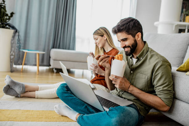 istock A lunch break for a young couple who is working on laptops from home 1289270159