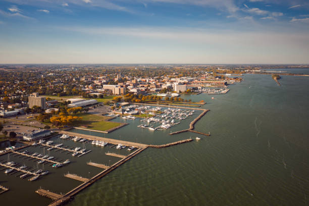 Incredible aerial city skyline panorama photograph of Sandusky, Ohio from the shoreline of the bay in Lake Erie with parks and harbors seen below on a sunny day. stock photo