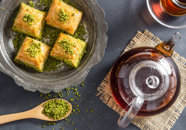 istock Traditional turkish dessert pistachio antep baklava with turkish black tea on rustic table,  ramadan or holiday desserts concept 1289272548