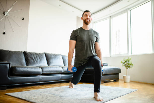 joven deportista que tiene entrenamiento deportivo con mancuernas en casa - lunge fotografías e imágenes de stock