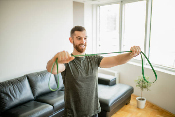 istock Sporty man  doing exercises with resistance band at home 1289273271