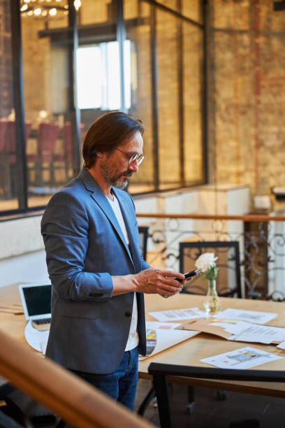 istock Serious brunette man checking his phone updates 1289273371