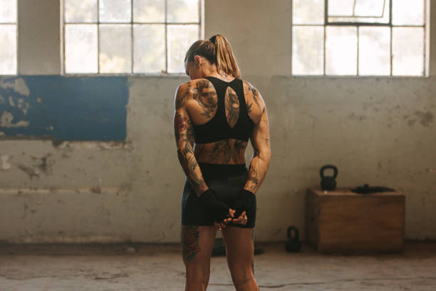 istock Tattooed woman boxer in old warehouse 1289275452