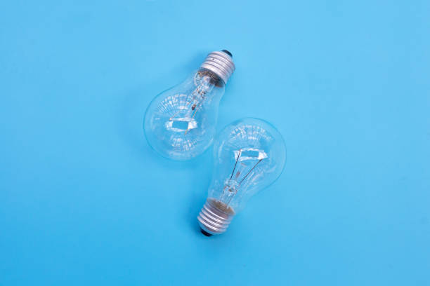 istock Light bulbs on blue background. Ideas and creative thinking concept. Top view 1289275505