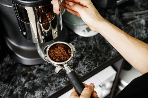 istock Woman coffee shop worker preparing coffee on professional coffee machine 1289275592