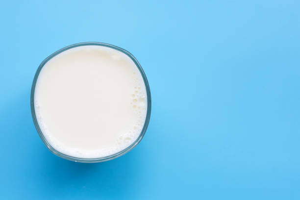 istock Glass of milk on blue background. Copy space 1289275770