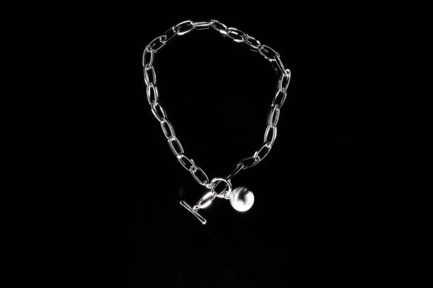 istock Silver jewelry chain with medallion isolated on black background 1289277353