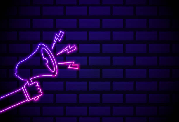 istock Hand with loudspeaker neon sign. Bright glowing symbol on a dakr brick wall background. Neon style icon. 1289278202