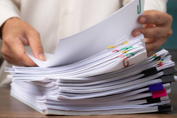 istock Business man hand pick up Stack overload document report paper with colorful paperclip, business and paperless concept. 1289279072