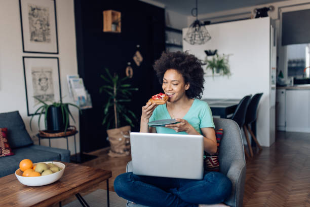 istock Young woman starting to work and eating her breakfast at home 1289280524