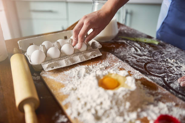 istock Attentive baker picking an egg to add to the dough mix 1289280804