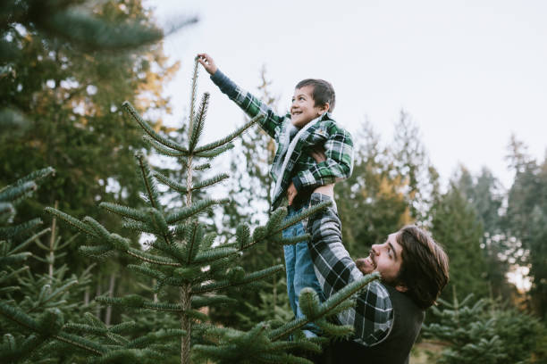 Family At Local Christmas Tree Farm Picking Tree