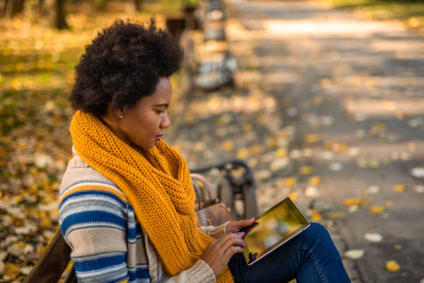 istock African American woman using digital tablet in the public park. 1289286484
