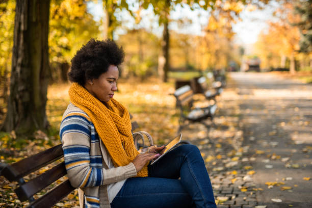 istock African American woman using digital tablet in the public park. 1289287127