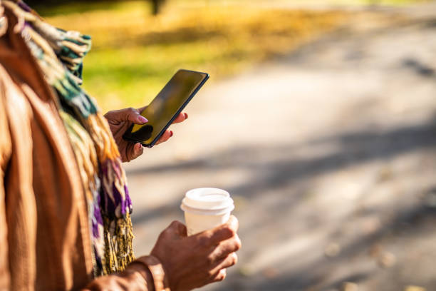istock Unrecognizable Young African American woman using mobile phone at public park. 1289287297