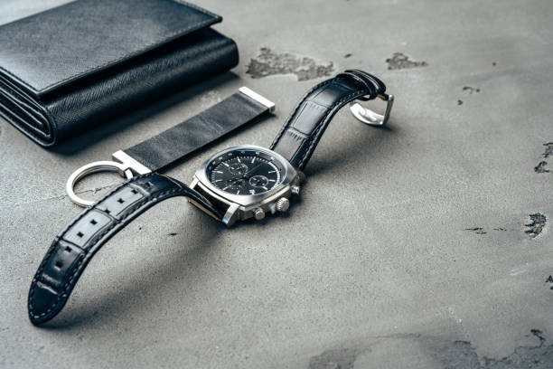 istock Male watch and leather wallet on dark grey surface 1289288102
