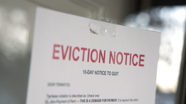 Paper Eviction Notice Taped to the Front Door of a Rental Home in a Residential Suburban Neighborhood