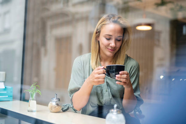 istock Introspective Young Woman Enjoying Coffee in Cafe Window 1289288887