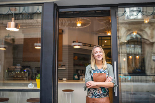 istock Welcoming Young Cafe Owner Standing at Front Door 1289288889