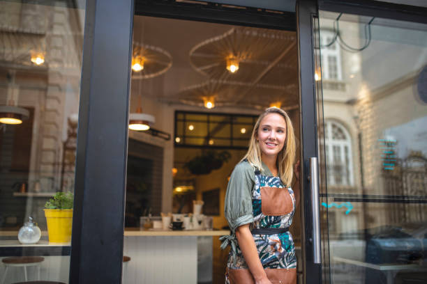 istock Smiling Small Business Owner Standing at Cafe Front Door 1289288905