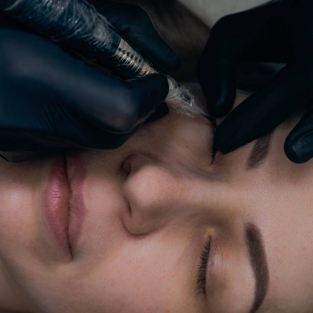 istock Permanent eyebrow makeup procedure. Eyebrow tattooing, process. The use of tools by a master for permanent eyebrow makeup. 1289288995