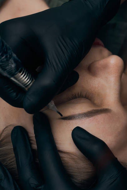 istock Permanent eyebrow makeup procedure. Eyebrow tattooing, process. The use of tools by a master for permanent eyebrow makeup. 1289289001