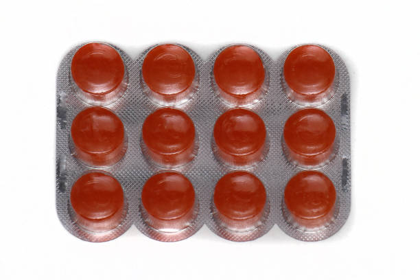 Orange flavour sore throat lozenges medicine in silver blister on white background