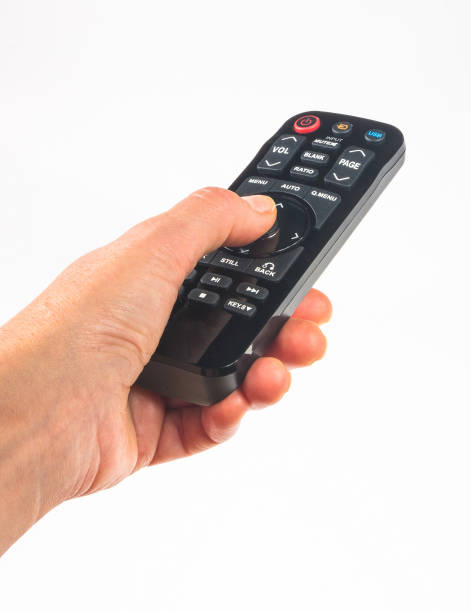 istock hand holding a remote control on white background, close-up 1289293851