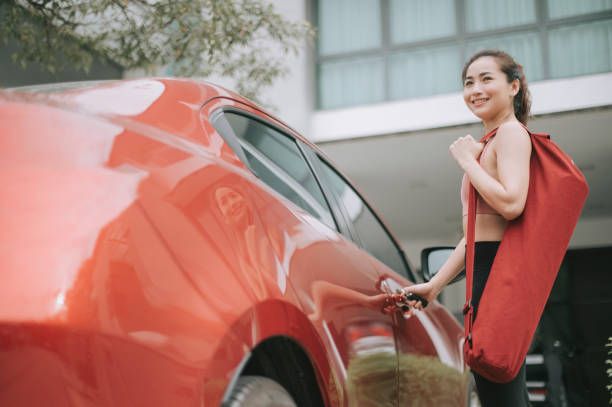 asian chinese beautiful woman getting ready to go for yoga class getting her car at parking garage asian chinese beautiful woman getting ready to go for yoga class getting her car at parking garage car door photos stock pictures, royalty-free photos & images