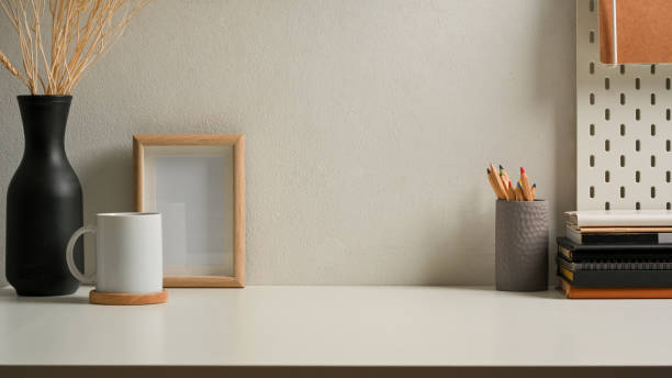 istock Worktable with stationery, frame, cup and decorations in home office 1289300631